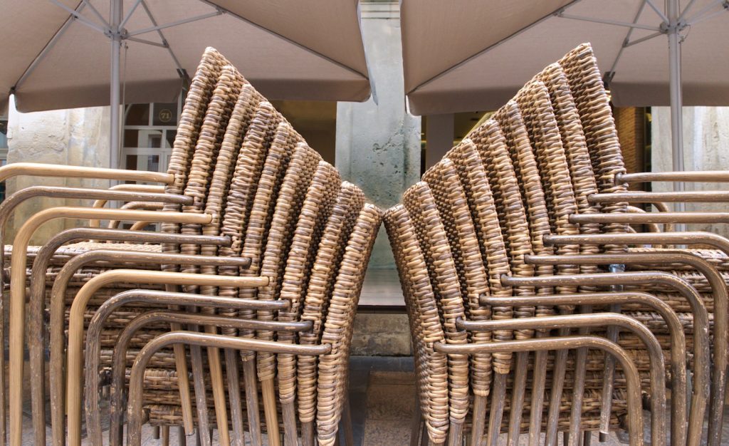 A bunch of chairs with umbrellas in the background